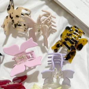 Elegant 3D butterfly acetate hair claws in various colors set on soft white fabric