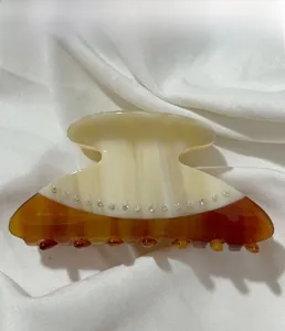 Detail of cream and tortoiseshell acetate hair claw clip with inlaid rhinestones