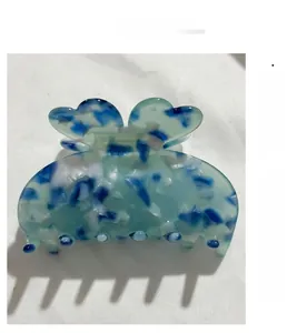 Vue détaillée de la pince à cheveux trèfle en acétate marbré bleu avec finition lisse