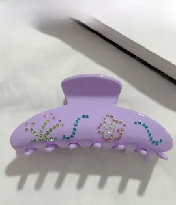 Details einer lavendelfarbenen Haarklammer mit bunten Strasssteinen in Blumenmustern