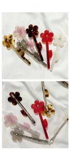 Détail des barrettes à fleurs en résine avec strass central et structure métallique