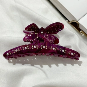 Dettaglio della pinza per capelli a farfalla viola con perle e strass luccicanti