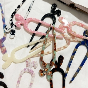 Forcina per capelli a U in acetato con motivi tartarugati e marmorei su tessuto bianco