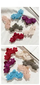 Detail showing acetate flower hair claws with rhinestones in six various colors