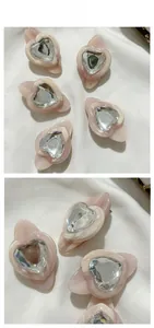 Détail de pinces à cheveux en acétate avec cœurs roses, strass et centre argenté poli