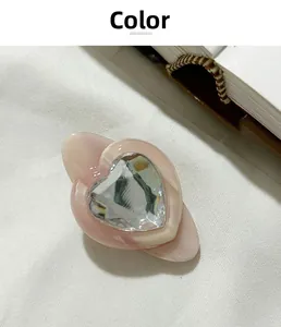 Détail de la pince à cheveux cœur en résine rose marbrée avec un cristal à facettes