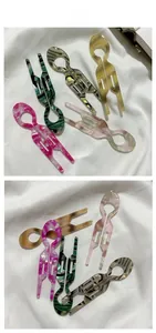 Épingles à cheveux en forme de U en acétate marbré montrant cinq couleurs sur tissu blanc