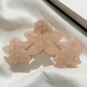 Detail view of pink acetic flower hair claw with sparkling rhinestones decoration