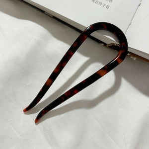 Detailed view of U-shaped acetate hair pin with vintage tortoiseshell texture