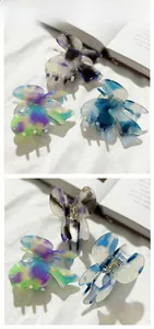 Detail view of butterfly hair claws with marble texture in purple, blue and green shades
