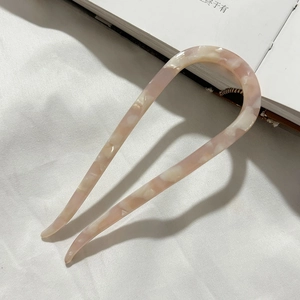 Detail of pink marble acetate U-shaped hair fork pin with glossy tortoiseshell texture