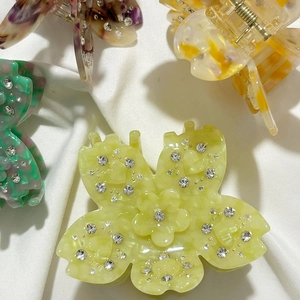 Pinces à cheveux fleurs en acétate avec strass en quatre couleurs élégantes sur tissu