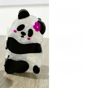 Vue détaillée d'une pince à cheveux panda en acétate marbré ornée de petites fleurs roses
