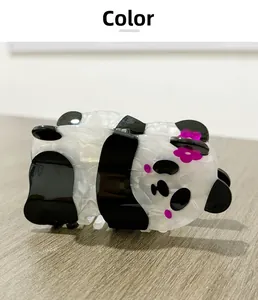 Détail d'une pince à cheveux panda en acrylique marbré noir et blanc avec fleur