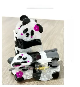 Détail d'une pince à cheveux panda avec fleur violette et texture en acétate chic