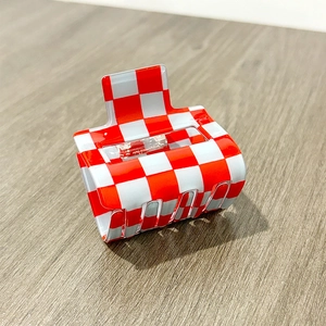 Detail view of red and white checkered hair claw clip with sturdy metal spring