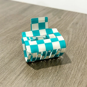 Macro detail of checkered square hair claw with light blue and white pattern
