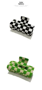 Detail view of black and green checkerboard hair claws with a high-gloss finish