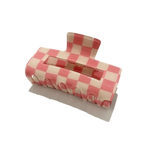Macro shot of pink and cream checkered hair claw clip with glossy acrylic finish