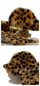 Detail view of the metal spring hinge and golden puppy head outline on leopard hair claw
