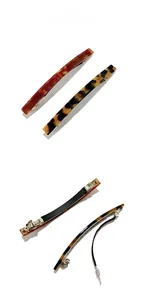 Detail view of acetate spring hair clips in tortoiseshell and amber patterns with metal base