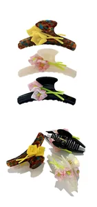 Detail view of acetate floral shark clips in tortoiseshell, cream and black finishes