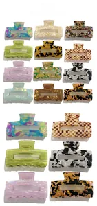 Close-up of hollow rectangular hair claws in marble, checkered, and amber patterns