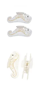Vue détaillée de la pince à cheveux hippocampe en acétate blanc perle et motifs dorés