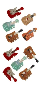 Macro detail of guitar and violin shaped acrylic hair claws with marble texture