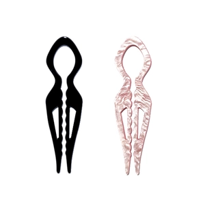 Detail view of U-shaped acrylic hair pins in solid black and pink marble textures