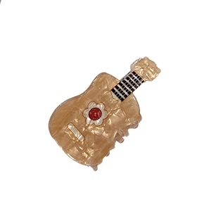 French minimalist guitar claw clip with pearlescent finish and small floral details