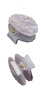 Detail of lavender shell-shaped hair claw with shimmering crystals and golden spring