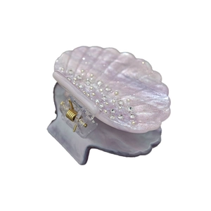 French shell-shaped sparkling hair claw with iridescent purple finish and inlaid rhinestones