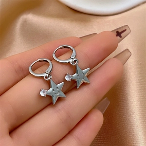 Détail de boucles d'oreilles étoile en argent avec gravure sourire et zircon brillant