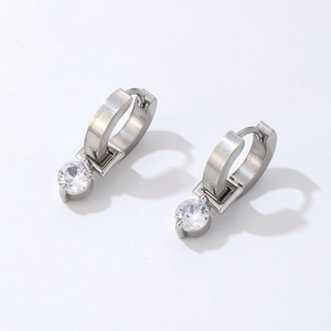 Detailed macro view of silver hoop earrings with cubic zirconia pendant and claw setting