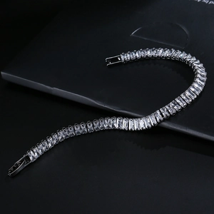 Macro shot of silver tennis bracelet with rectangular step-cut cubic zirconia crystals