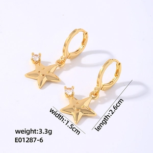 Vue détaillée des boucles d'oreilles étoiles dorées avec motif sourire et zircon