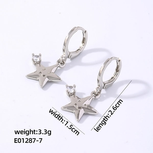 Détail de boucles d'oreilles étoiles argentées avec gravure smiley et pierre zircon
