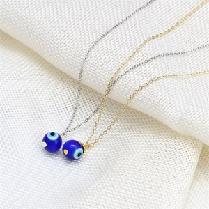 Primo piano di collane con ciondolo Occhio di Allah turco in oro e argento con perline blu