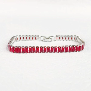 Macro view of silver-tone bracelet featuring rectangular red zircon stones in 4-prong setting