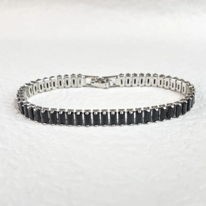 Detail of classic silver tennis bracelet featuring rectangular black cubic zirconia stones
