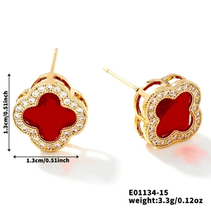 Vue détaillée des boucles d'oreilles trèfle doré avec incrustation rouge et cristaux