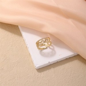 Detailed close-up of golden adjustable open ring with sparkling white zircon stones