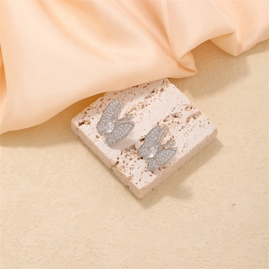 Elegant silver butterfly stud earrings with sparkling cubic zirconia on a stone display