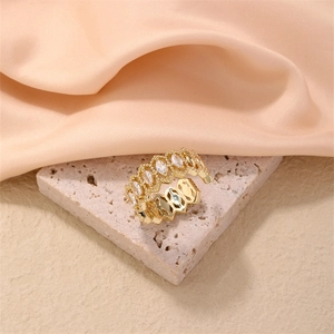 Detailed close-up of golden adjustable ring with marquise zircon stones on satin