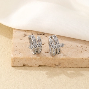Vue macro de boucles d'oreilles en argent avec zircons sertis sur surface en pierre