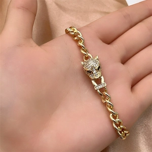 Macro shot of gold Cuban chain bracelet featuring a leopard head with micro-pave crystals