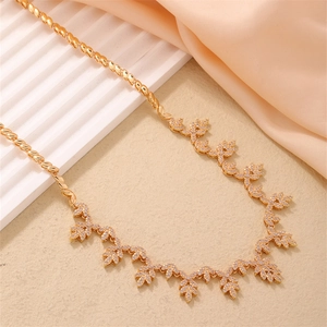 Elegant gold maple leaf necklace with sparkling crystals on decorative rope chain