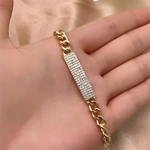 Close-up of gold Cuban chain bracelet with rectangular pavé-set crystal bar pendant