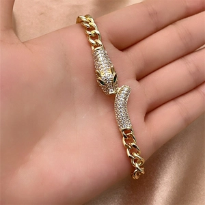 Macro detail of gold-plated cuban link bracelet with sparkling leopard head clasp closure
